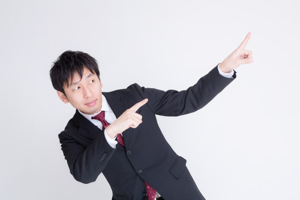 右上を指す男性