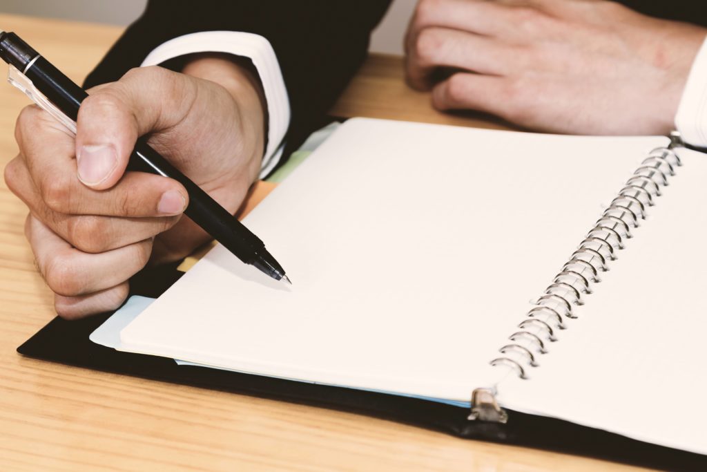 手帳に何かを書き込む